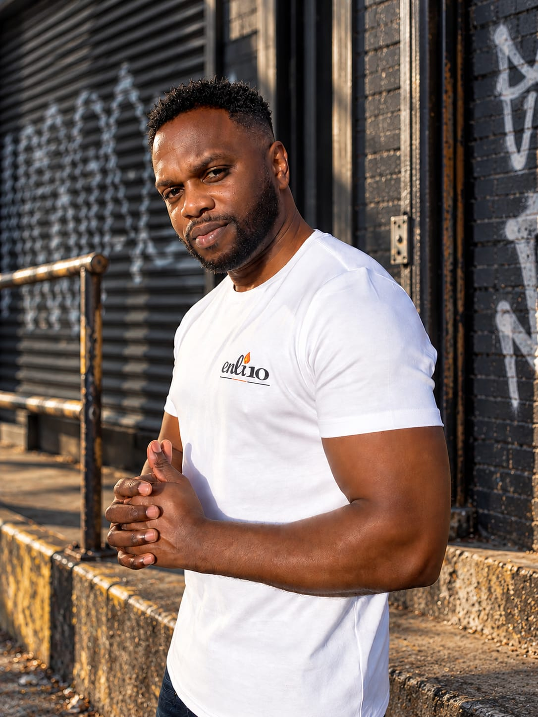 ENLI10 white logo T-shirt worn in an urban street setting